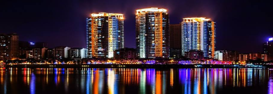 Panoramic view of Chongqing high-rise luxury towers and riverfront reflecting off Yangtze River from Nanbin Road at night